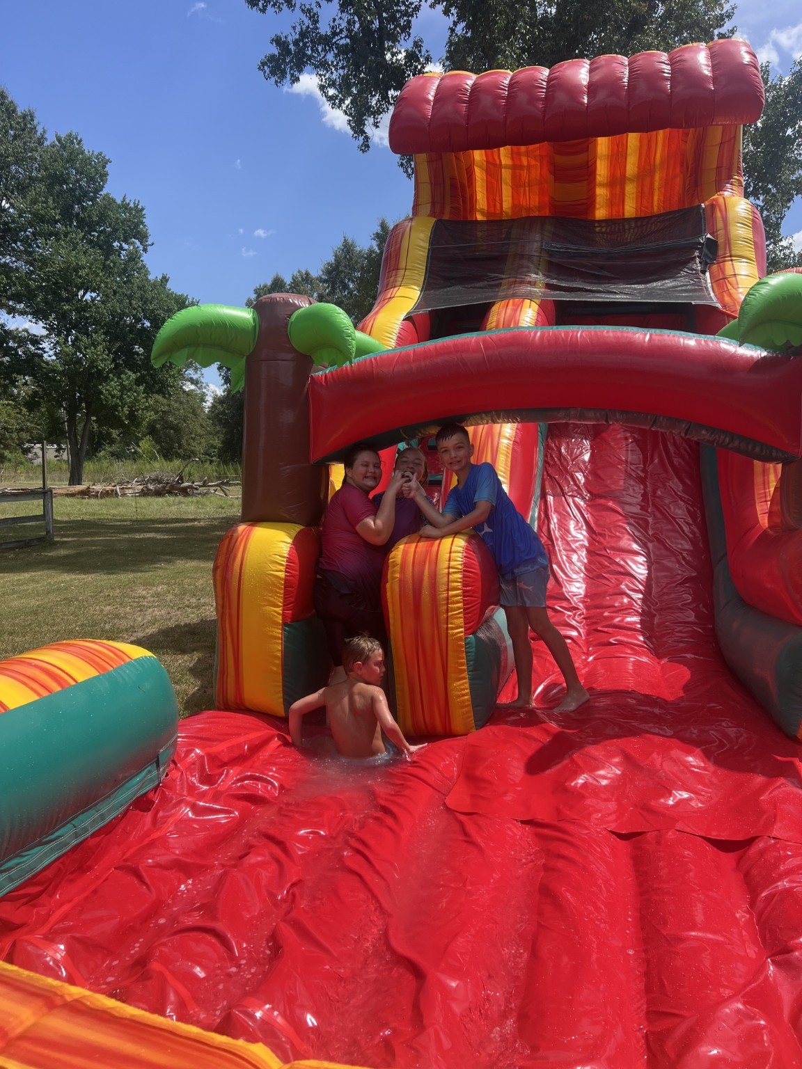 18-foot red tropical inflatable water slide in use from the splash area